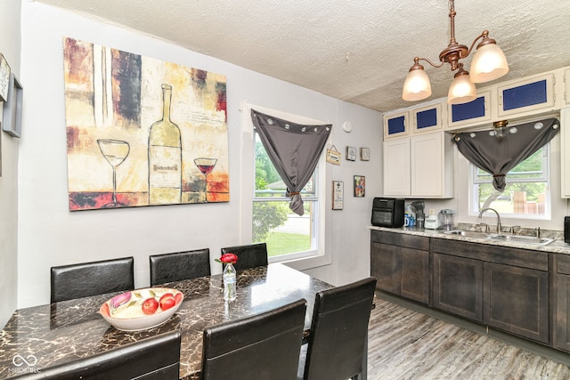 3302 N Gladstone Ave, Indianapolis, IN 46218 - kitchen with a sink, a chandelier, dark stone counters, a textured ceiling, and light wood-style flooring