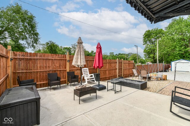 3302 N Gladstone Ave, Indianapolis, IN 46218 - view of patio with an outdoor fire pit, a fenced backyard, a storage shed, and an outbuilding