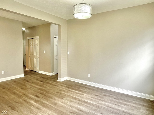 spare room featuring wood finished floors and baseboards