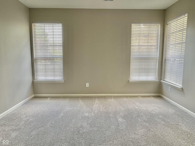 empty room featuring baseboards and carpet flooring