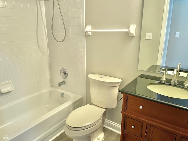 bathroom featuring baseboards, toilet, vanity, and shower / bath combination
