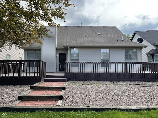 rear view of house featuring a deck and a shingled roof