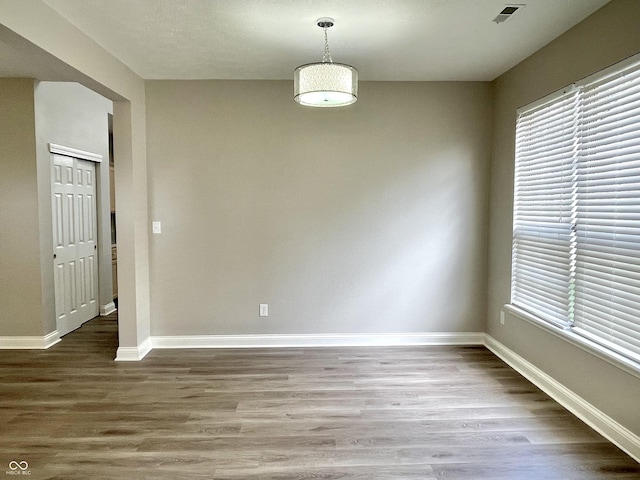 unfurnished dining area with wood finished floors, baseboards, and plenty of natural light