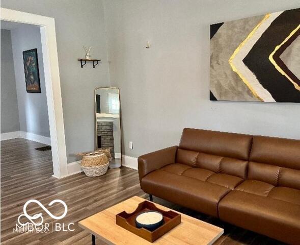 living room featuring baseboards, wood finished floors, and a fireplace