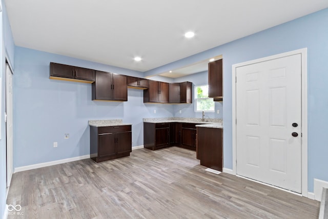 641 E 33rd St, Indianapolis, IN 46205 - kitchen with dark brown cabinetry, light wood finished floors, baseboards, light countertops, and recessed lighting