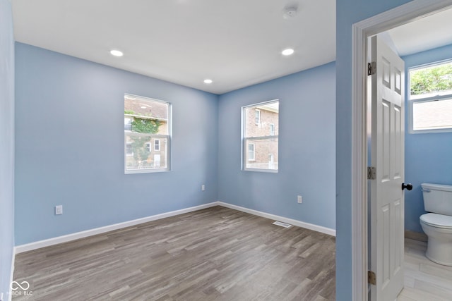 641 E 33rd St, Indianapolis, IN 46205 - unfurnished bedroom with wood finished floors, baseboards, and recessed lighting