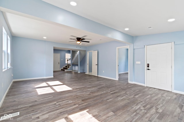 641 E 33rd St, Indianapolis, IN 46205 - unfurnished living room with wood finished floors, baseboards, stairs, a ceiling fan, and recessed lighting