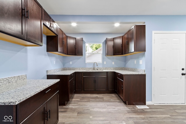 641 E 33rd St, Indianapolis, IN 46205 - kitchen with a sink, light wood-type flooring, dark brown cabinets, light stone countertops, and recessed lighting