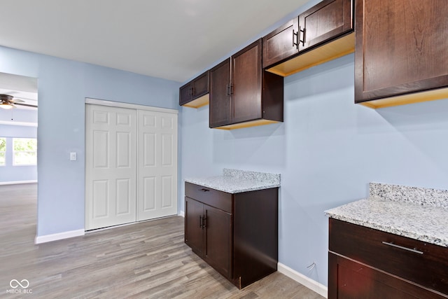 641 E 33rd St, Indianapolis, IN 46205 - kitchen featuring dark brown cabinetry, light wood-type flooring, baseboards, light stone counters, and ceiling fan