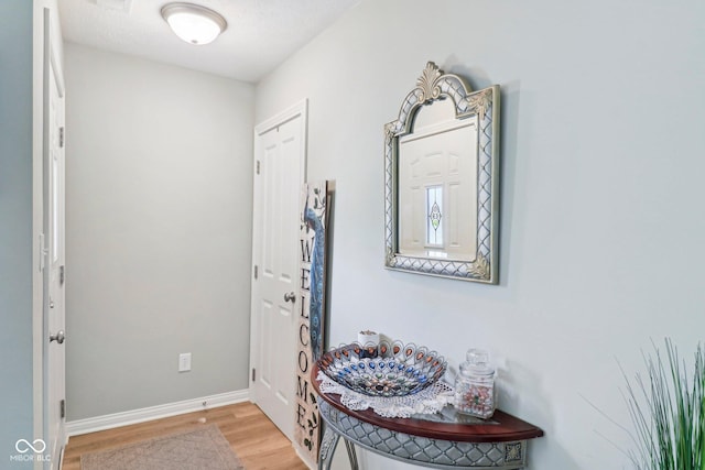foyer with light wood-style flooring and baseboards
