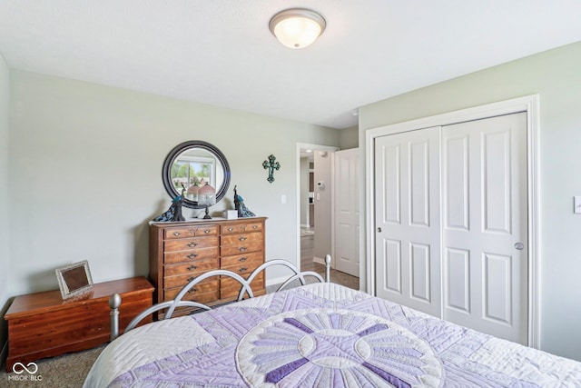 carpeted bedroom with a closet and baseboards