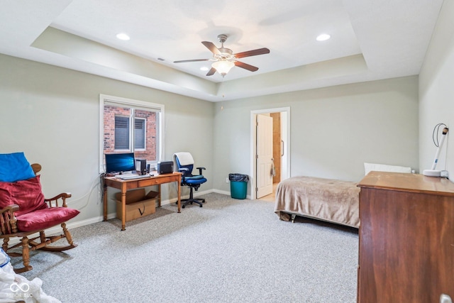 carpeted bedroom featuring an office area, baseboards, a raised ceiling, recessed lighting, and ceiling fan