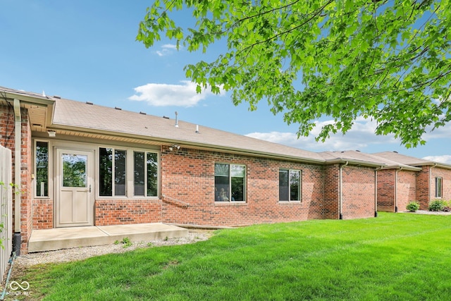 rear view of property with brick siding and a lawn