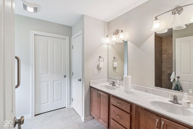 full bath featuring tile patterned floors, double vanity, and baseboards