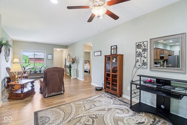 living room with wood finished floors, baseboards, and a ceiling fan