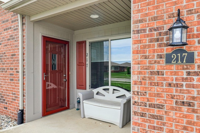 view of exterior entry featuring brick siding