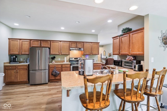 kitchen featuring appliances with stainless steel finishes, under cabinet range hood, brown cabinetry, and recessed lighting