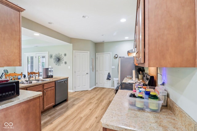 kitchen featuring dishwasher, a sink, light wood-style floors, brown cabinets, and recessed lighting