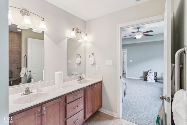 bathroom with ensuite bathroom, ceiling fan, double vanity, and baseboards