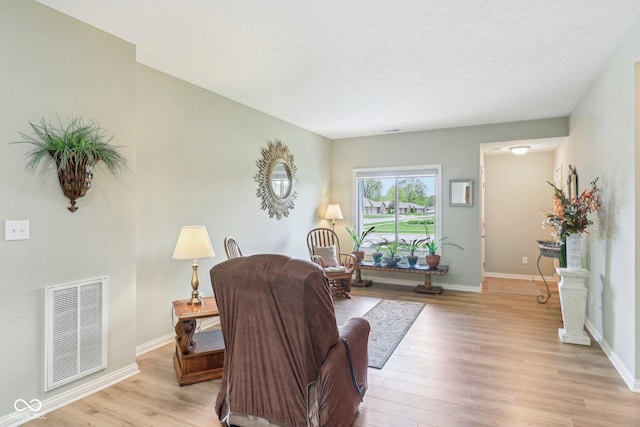 living area featuring light wood-type flooring and baseboards