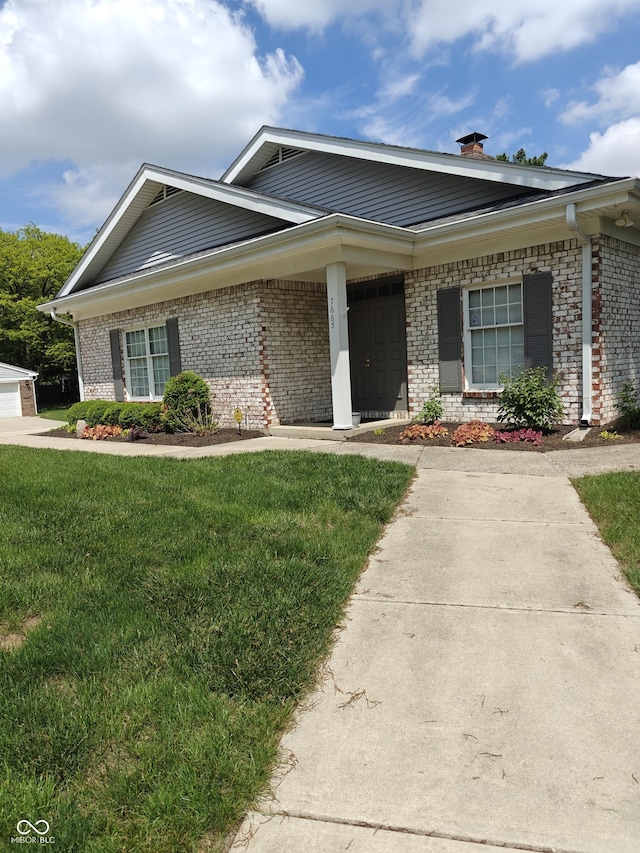7642 Lancer Ln, Lawrence, IN 46226 - view of front of house featuring brick siding, a front lawn, and a chimney