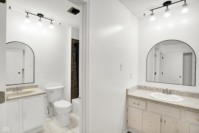 7642 Lancer Ln, Lawrence, IN 46226 - bathroom featuring a textured ceiling, tile patterned floors, rail lighting, two vanities, and toilet