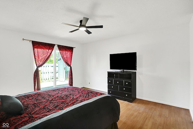 7642 Lancer Ln, Lawrence, IN 46226 - bedroom with light wood-type flooring, a textured ceiling, access to outside, baseboards, and a ceiling fan