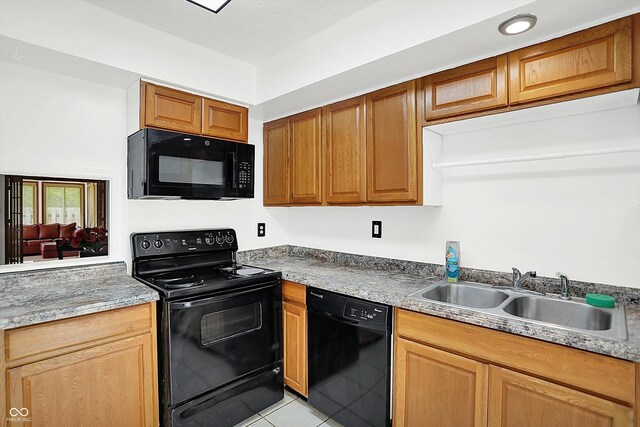 7642 Lancer Ln, Lawrence, IN 46226 - kitchen featuring black appliances, a sink, light tile patterned floors, and light countertops