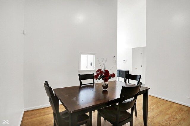 7642 Lancer Ln, Lawrence, IN 46226 - dining area featuring light wood-style flooring, a high ceiling, and baseboards