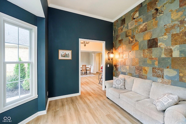 living room featuring ornamental molding, plenty of natural light, wood finished floors, and baseboards