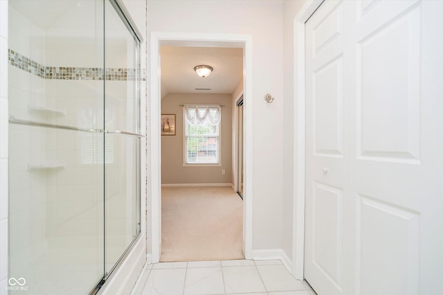 bathroom with a shower with shower door and baseboards