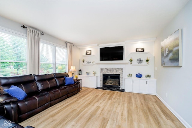 living room with wood finished floors and a fireplace with flush hearth