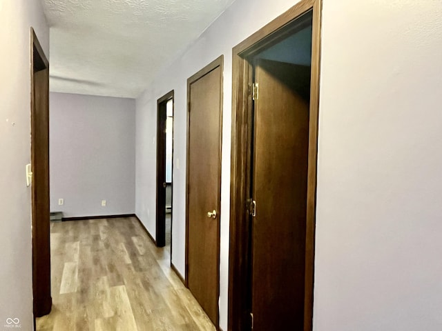 124 Brookside Dr, Hope, IN 47246 - hall with light wood-type flooring, baseboards, and a baseboard heating unit