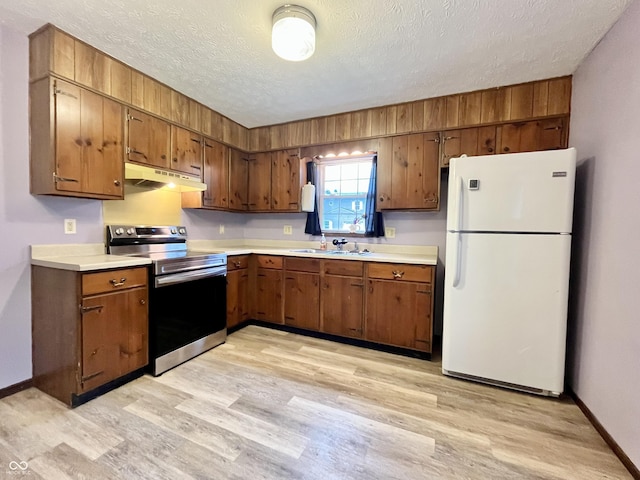 124 Brookside Dr, Hope, IN 47246 - kitchen featuring freestanding refrigerator, stainless steel electric stove, under cabinet range hood, a sink, and light countertops