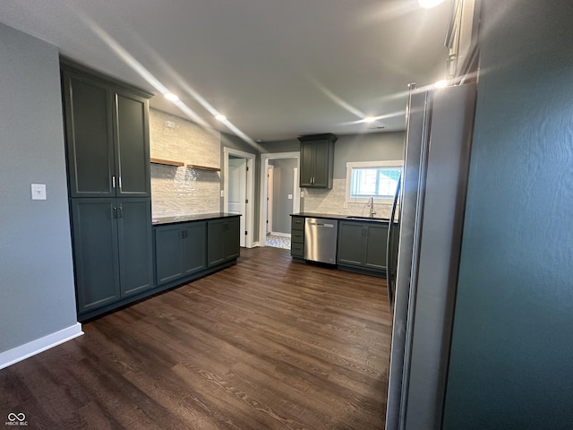 kitchen with dishwasher, a sink, dark wood finished floors, backsplash, and baseboards