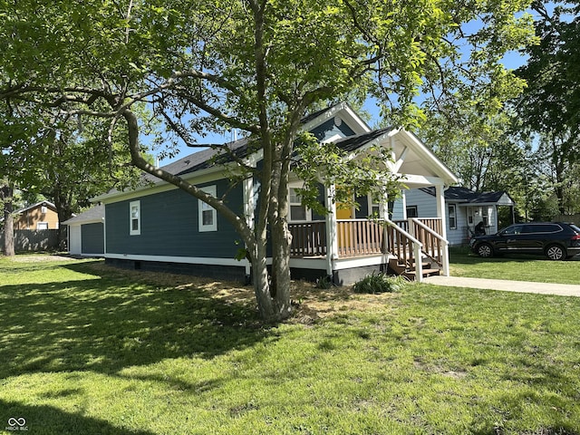 bungalow with covered porch and a front lawn