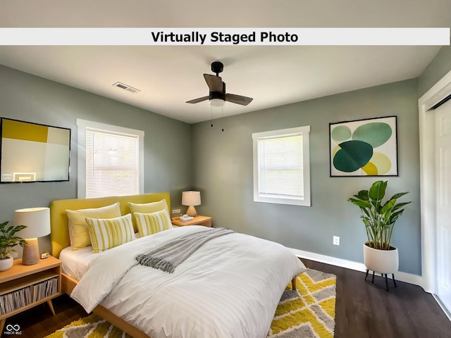 bedroom featuring dark wood finished floors, multiple windows, baseboards, and a ceiling fan