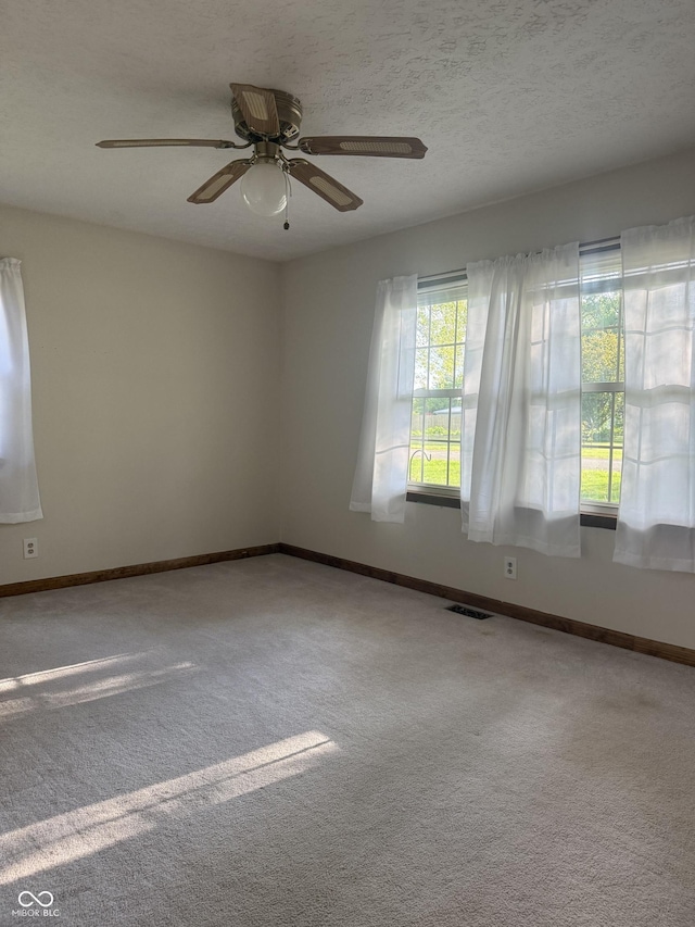 empty room with a ceiling fan, carpet floors, and baseboards