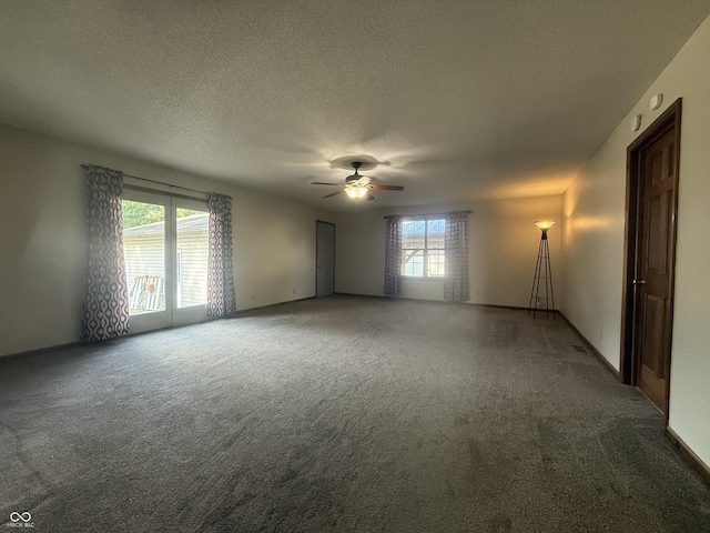 carpeted empty room featuring plenty of natural light, a textured ceiling, and a ceiling fan