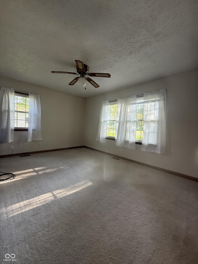 spare room featuring baseboards, a ceiling fan, a textured ceiling, and carpet floors