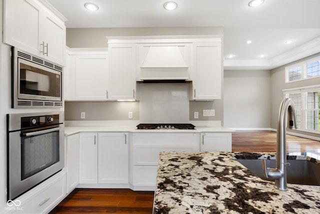 888 Westcreek Dr, Columbus, IN 47201 - kitchen featuring appliances with stainless steel finishes, custom exhaust hood, dark wood-style flooring, white cabinetry, and recessed lighting