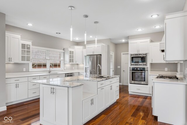 888 Westcreek Dr, Columbus, IN 47201 - kitchen with appliances with stainless steel finishes, white cabinets, glass insert cabinets, a center island with sink, and dark wood-style floors