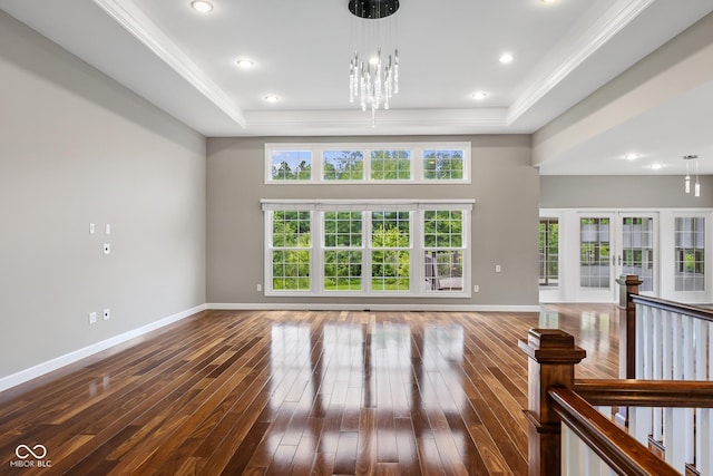 888 Westcreek Dr, Columbus, IN 47201 - unfurnished living room featuring a tray ceiling, dark wood-type flooring, plenty of natural light, and ornamental molding