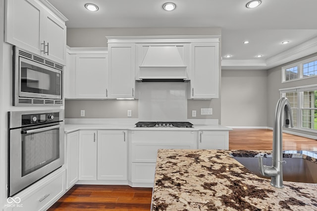888 Westcreek Dr, Columbus, IN 47201 - kitchen with stainless steel appliances, custom exhaust hood, dark wood finished floors, white cabinets, and recessed lighting