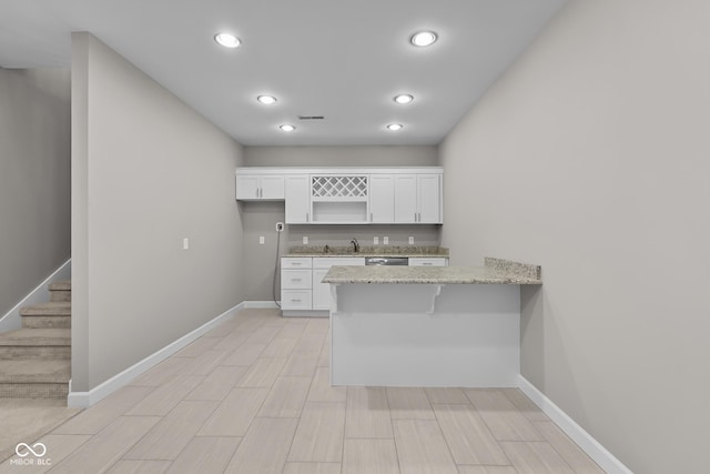 888 Westcreek Dr, Columbus, IN 47201 - kitchen featuring white cabinets, a peninsula, light stone counters, recessed lighting, and a breakfast bar