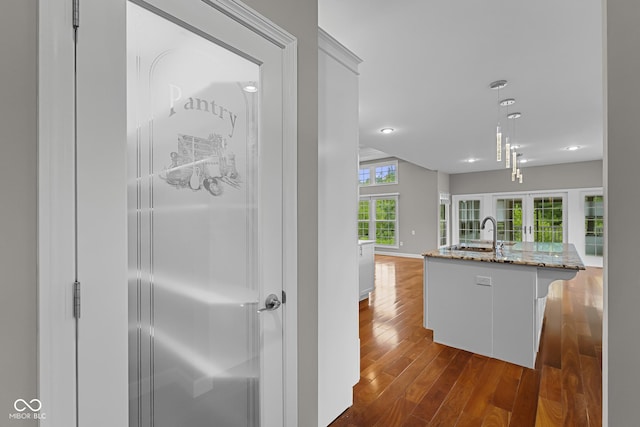 888 Westcreek Dr, Columbus, IN 47201 - kitchen view of light stone countertops, dark wood finished floors, recessed lighting, decorative light fixtures, and a kitchen island with sink