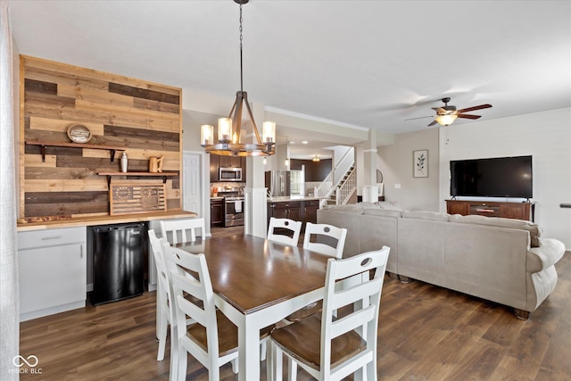 695 Bobtail Dr, Greenfield, IN 46140 - dining room with dark wood-style floors, a ceiling fan, a chandelier, wooden walls, and stairs