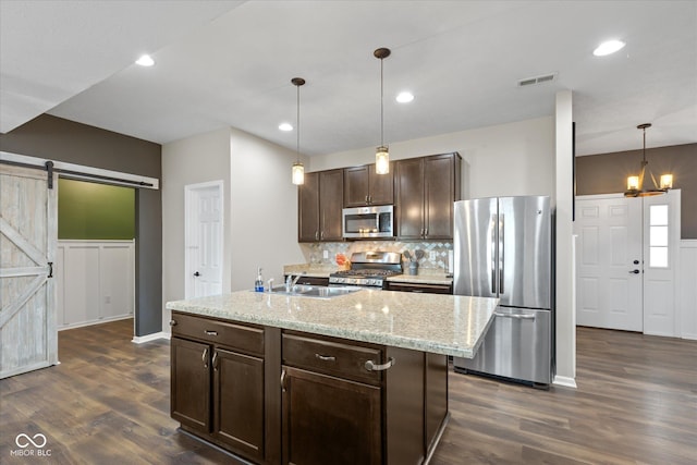 695 Bobtail Dr, Greenfield, IN 46140 - kitchen featuring appliances with stainless steel finishes, a sink, a barn door, dark brown cabinetry, and dark wood-type flooring