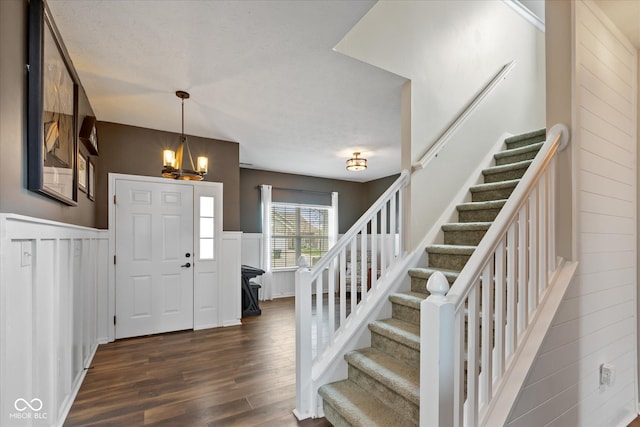 695 Bobtail Dr, Greenfield, IN 46140 - foyer entrance featuring stairs, dark wood-style floors, a chandelier, a decorative wall, and wainscoting
