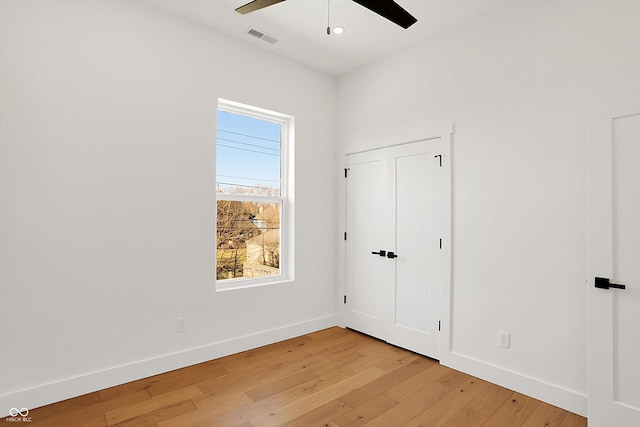 unfurnished bedroom with light wood-type flooring, baseboards, and ceiling fan
